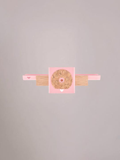 Achterzijde van het lichtroze wandplankje met ophangpunten.