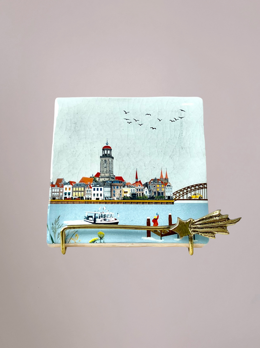StoryTiles tegeltje Zwaaiend Naar Deventer met meisje aan rivier dat naar stad zwaait en stadsgezicht op keramisch tegeltje