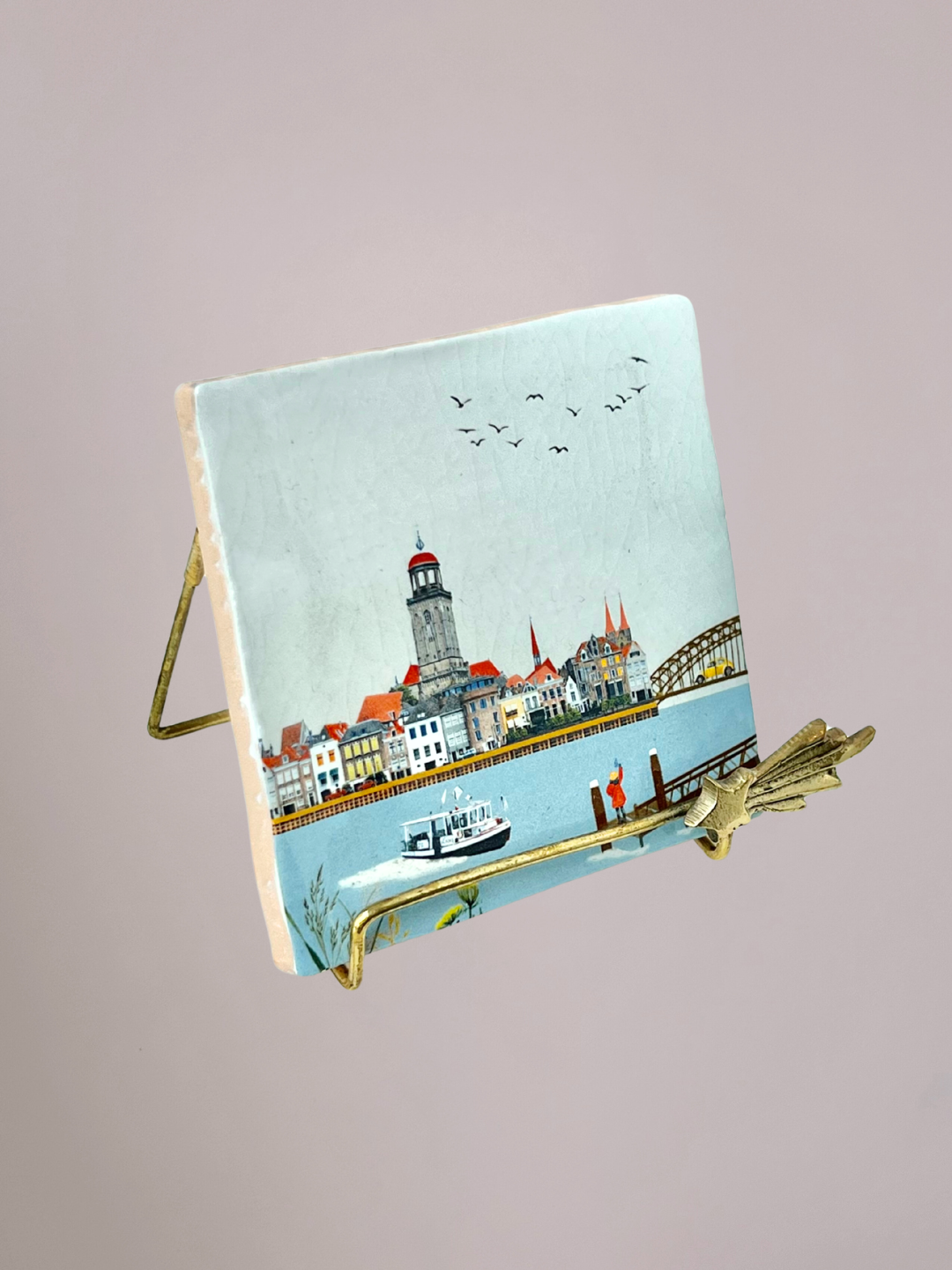 StoryTiles tegeltje Zwaaiend Naar Deventer met meisje aan rivier dat naar stad zwaait en stadsgezicht op keramisch tegeltje